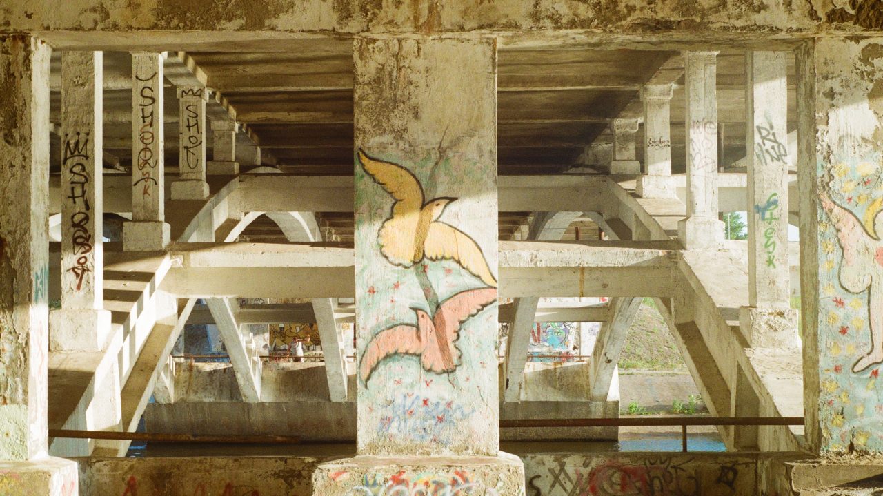 Header image depicting two hand-drawn doves on a pillar under a bridge.