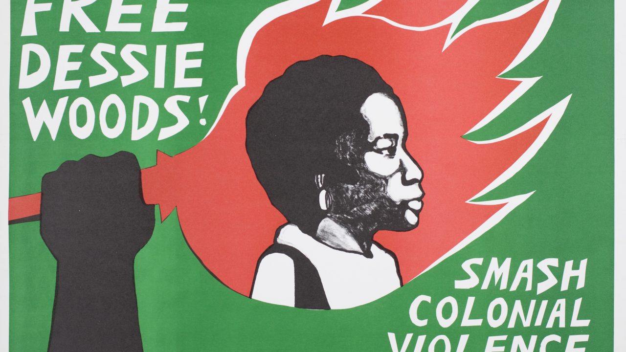 A 70s-era activism poster with a lime green background shows a black hand holding an image of incarcerated domestic abuse survivor Dessie Woods inside of a red flashing torch. Against the green background is written: “FREE DESSIE WOODS! SMASH COLONIAL VIOLENCE!“